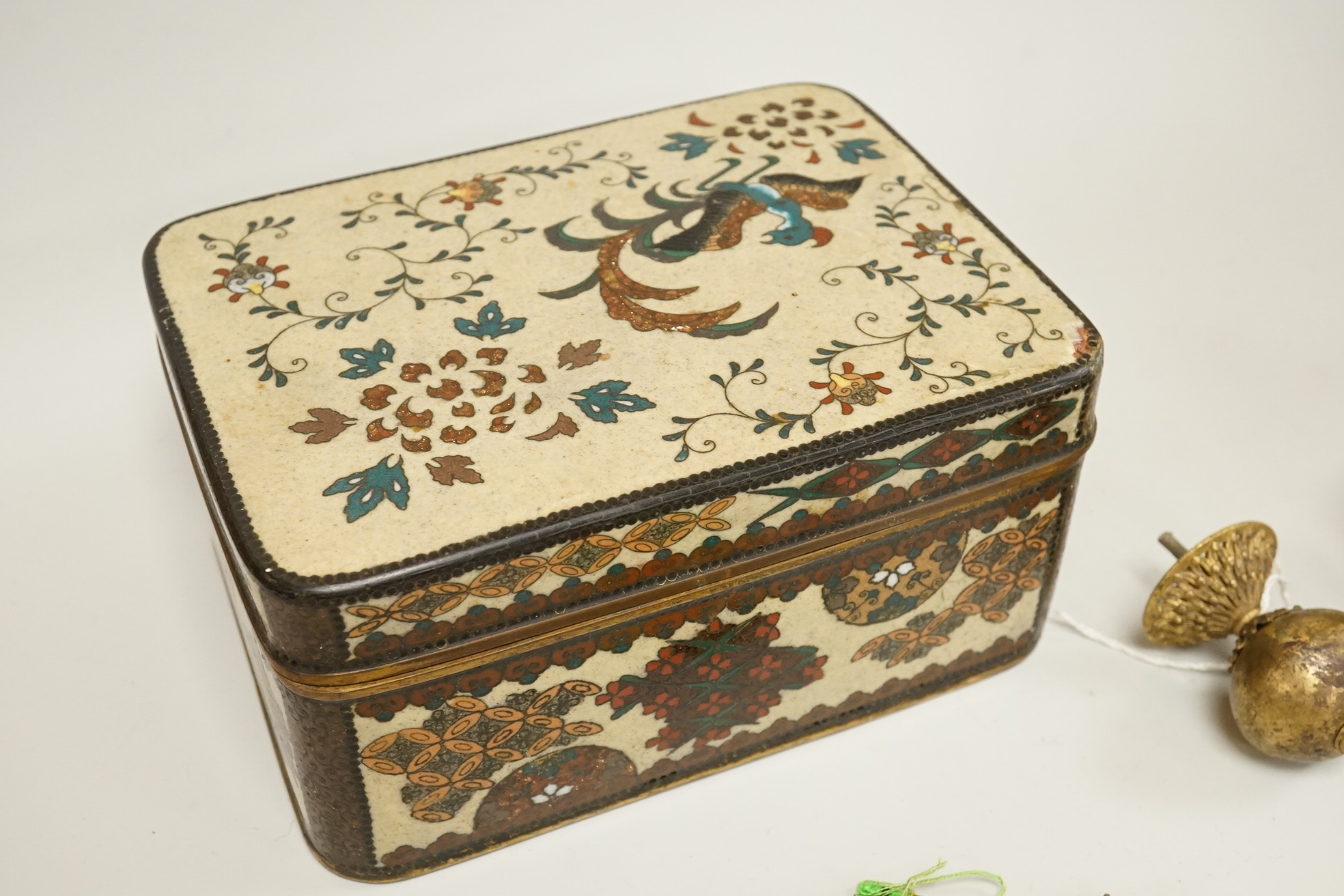 A large cloisonné enamel box containing a cast mask handle, an oval hair pendant, coins and medals, etc.